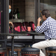 A man eating at a sidewalk table in a restaurant in New York City